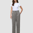 Kvinde iført en hvid T-shirt og grå Women Ashryn Pants Wide Domino Herringbone med et struktureret bouclé-mønster.