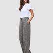 En kvinde i en hvid T-shirt og Women Ashryn Pants Wide Domino Herringbone-bukser i et klassisk dansk design.