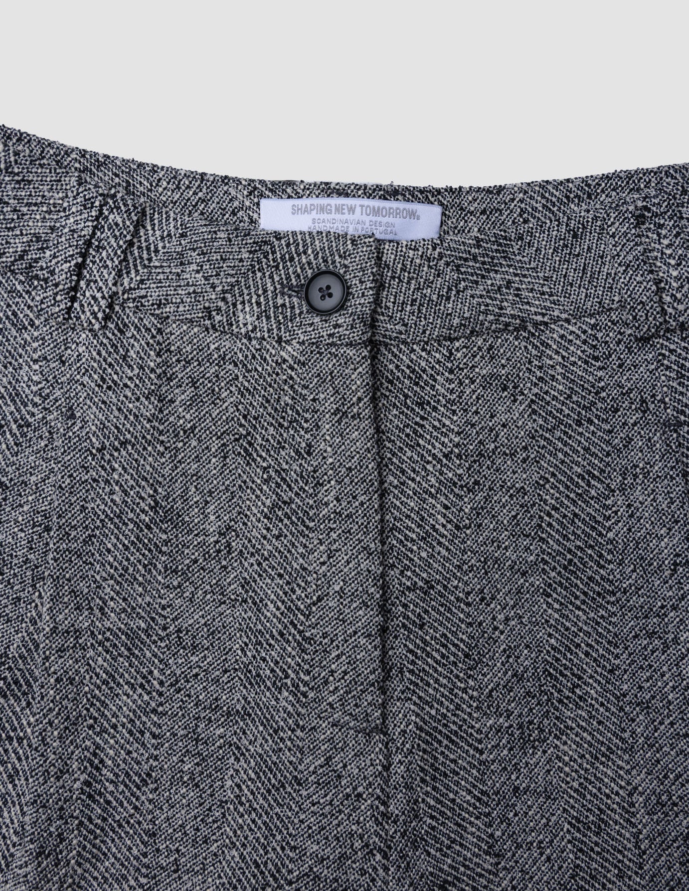Nærbillede af Women Ashryn Pants Wide Domino Herringbone med linning i gråt og sort bouclé og lukning med en enkelt knap.