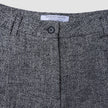 Nærbillede af Women Ashryn Pants Wide Domino Herringbone med linning i gråt og sort bouclé og lukning med en enkelt knap.