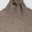Kvinders tykt strikket, blød uldtrøje med høj hals i taupe-melange: en taupe-farvet, groft strikket trøje i dansk design med ribbet høj hals.