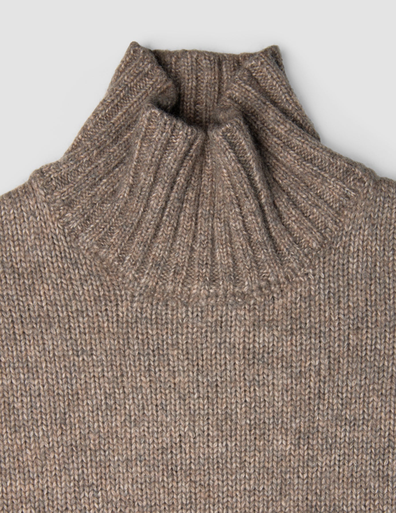 Kvinders tykt strikket, blød uldtrøje med høj hals i taupe-melange: en taupe-farvet, groft strikket trøje i dansk design med ribbet høj hals.