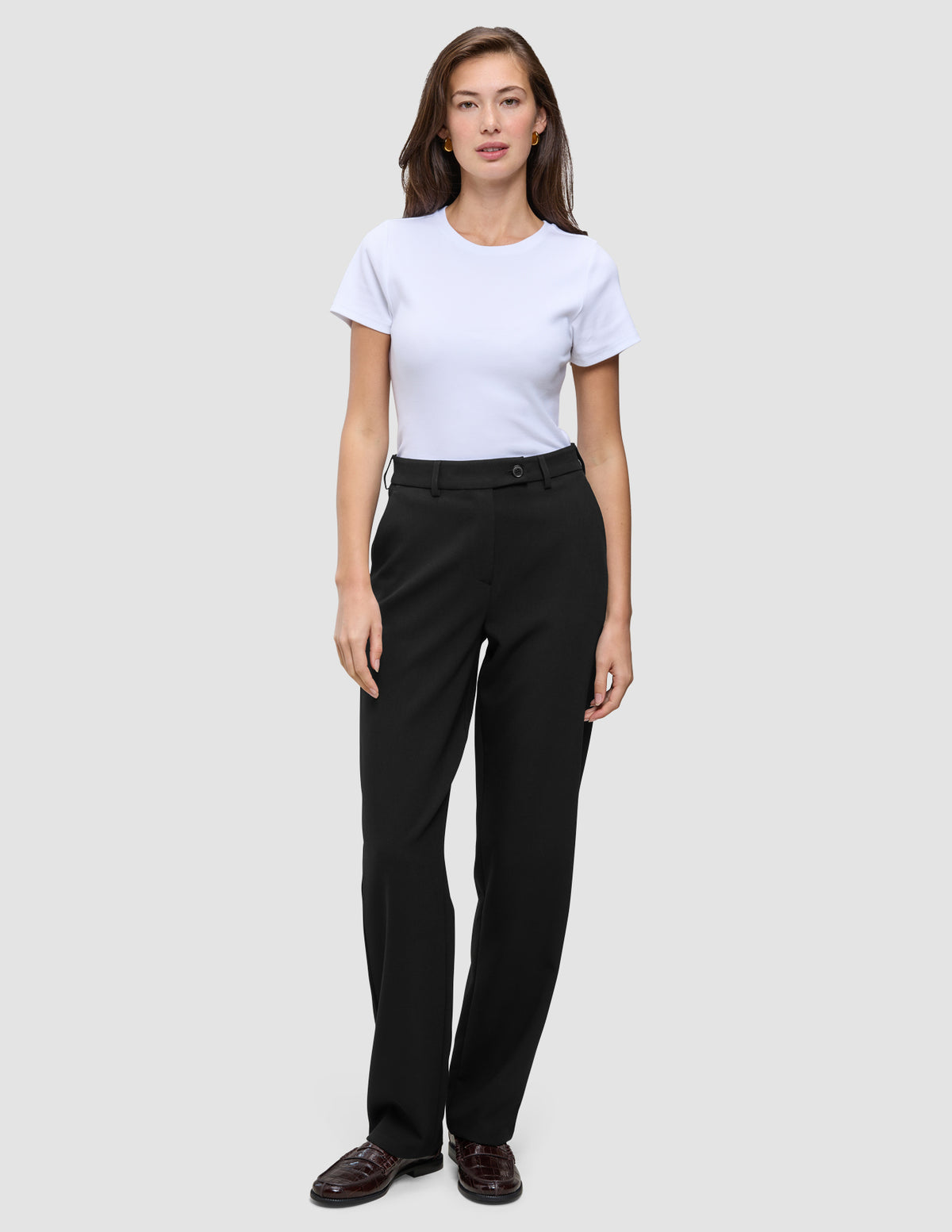En kvinde har en hvid T-shirt på og et par Women GO2 Pants Straight Black, der har høj talje og lige ben.