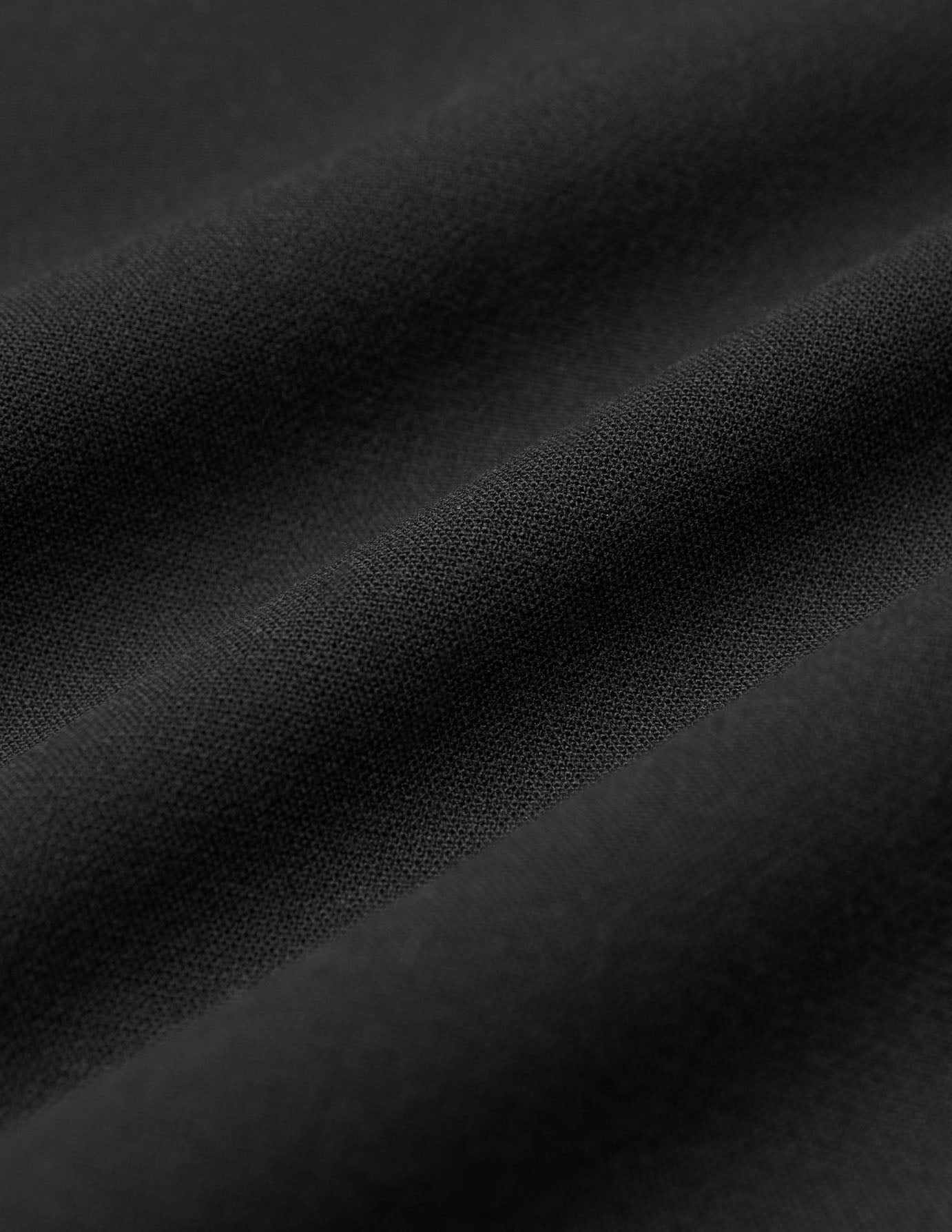 Nærbillede af sort stof med synlige folder i vores Women GO2 Pants Straight Black.