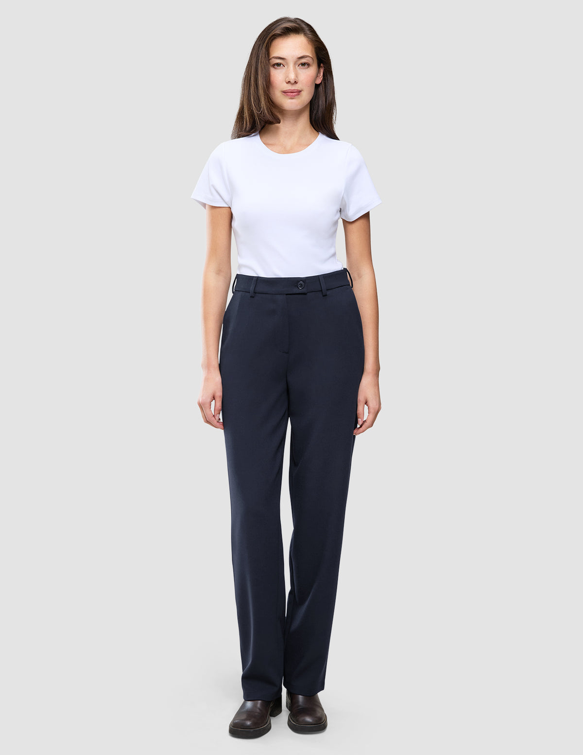 En kvinde iført en hvid T-shirt og Women GO2 Pants Straight Blue Nights i mørk marineblå.