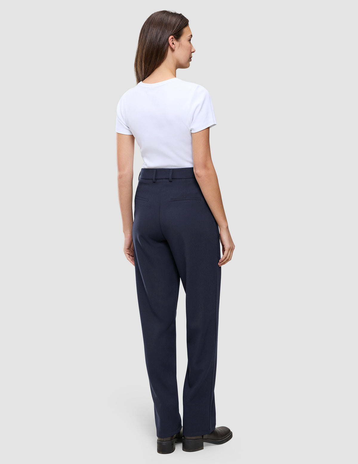 En person set bagfra, iført en hvid T-shirt og et par Women GO2 Pants Straight Blue Nights med lige ben.