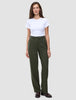 En kvinde i en hvid T-shirt, der er stukket ned i et par olivengrønne Women GO2-bukser i straight-fit i farven Dusty Olive, og mørke loafers.