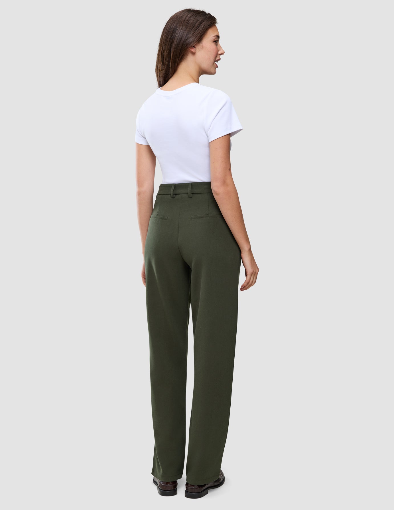 Kvinde iført en hvid T-shirt og Women GO2-bukser med høj talje i modellen Straight i farven Dusty Olive.