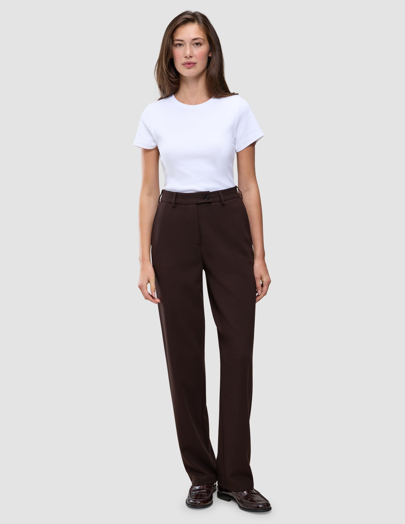 En kvinde iført en hvid T-shirt og Women GO2 Pants Straight Mocha.