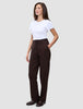 En kvinde i en hvid T-shirt og et par Women GO2 Pants Straight Mocha med hånden i lommen.