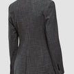 Bagfra-billede af en person, der bærer en Women Nara Blazer Fitted Black Check med et figurbetonende sort-hvidt ternet mønster.