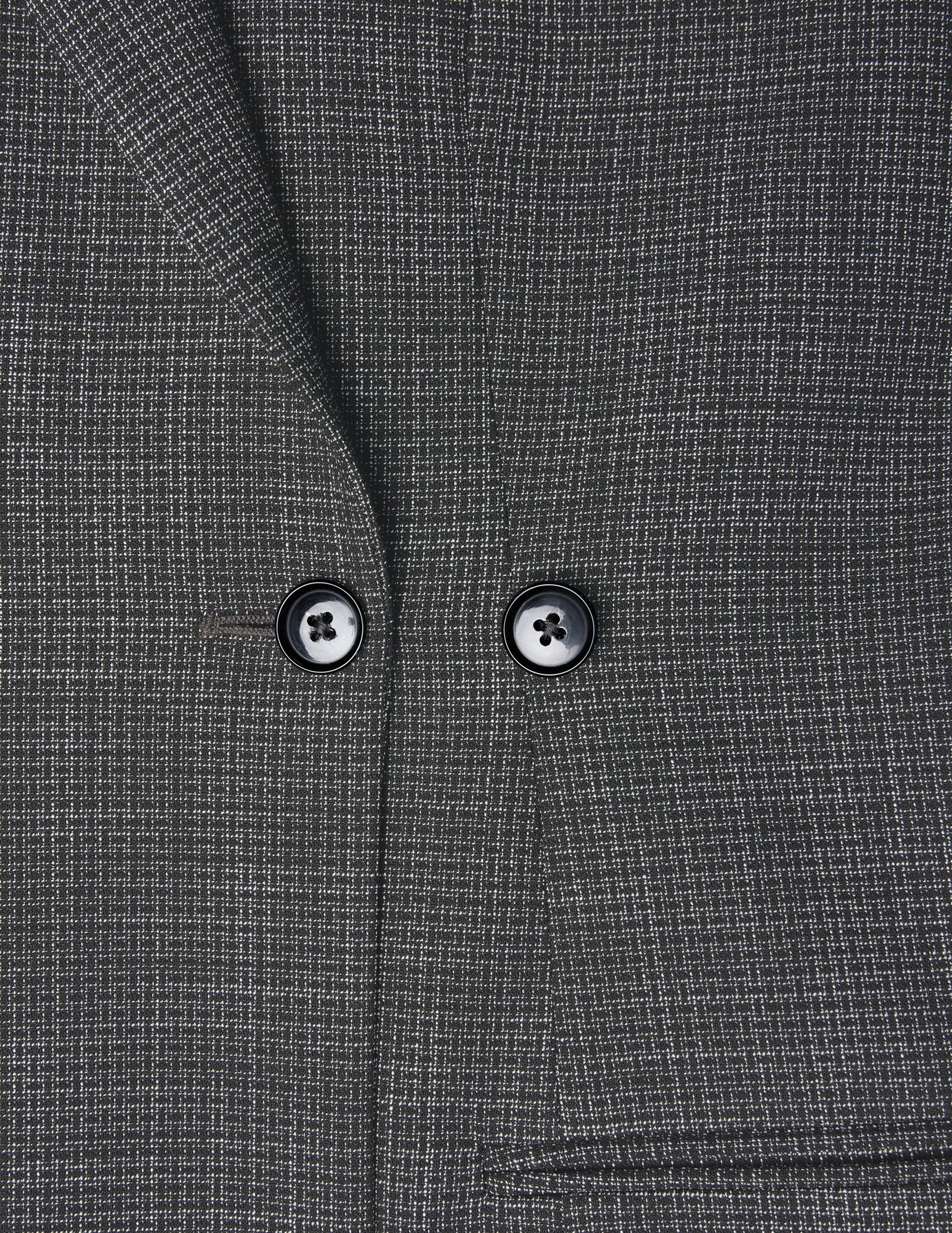 Nærbillede af en Women Nara Blazer Fitted Black Check – en antracitgrå ternet blazer med to sorte knapper.