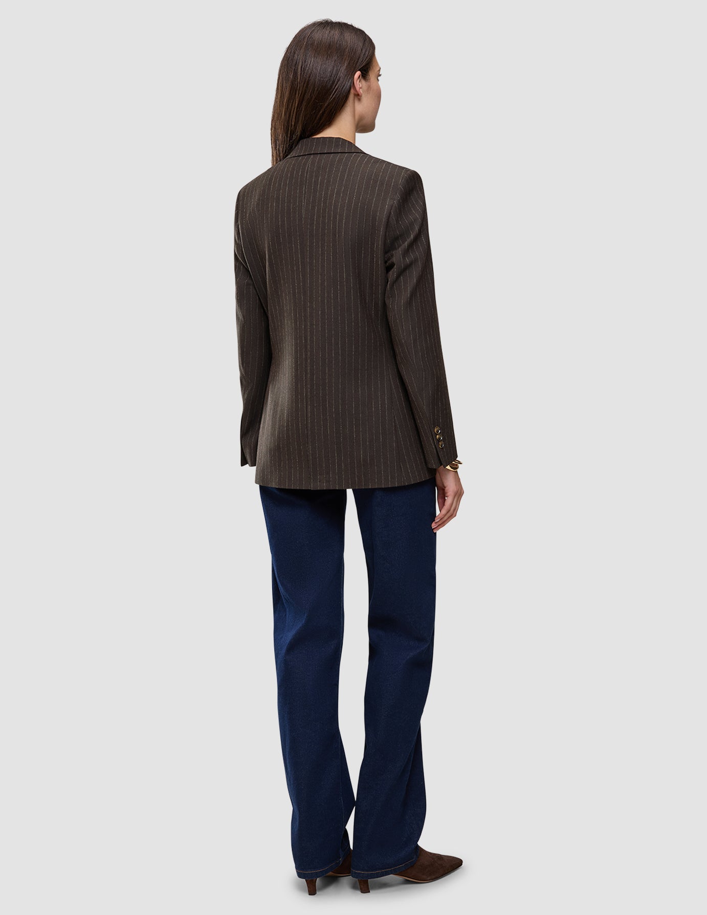 Bagfra-billede af en person iført en Women Serene Blazer Regular Walnut Herringbone, mørkeblå jeans og brune sko.