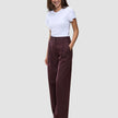 En kvinde har en hvid T-shirt på og et par Women Serene Pants Wide Berry Pinstripe med høj talje og brede ben.
