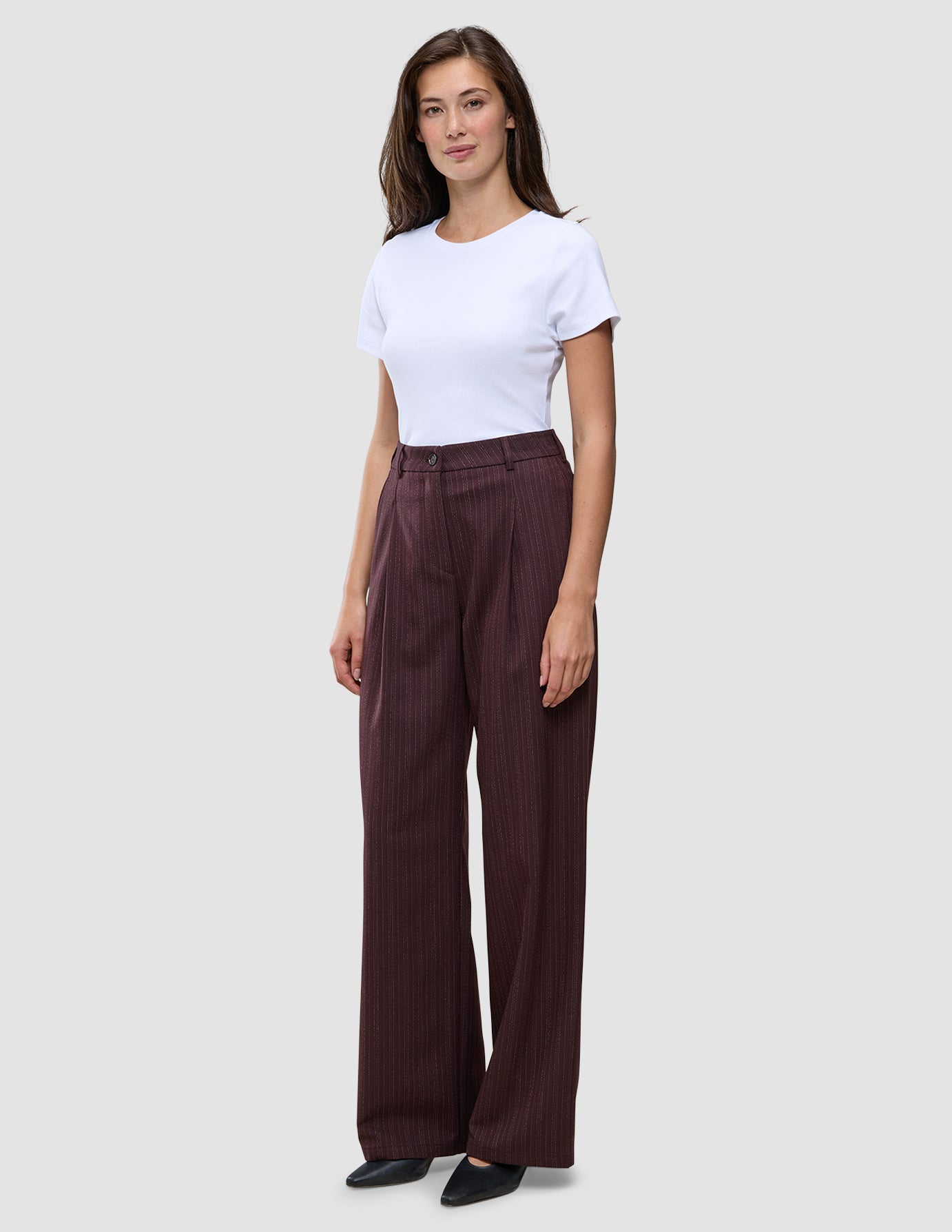 En kvinde iført en hvid T-shirt og et par Women Serene Pants Wide Berry Pinstripe.