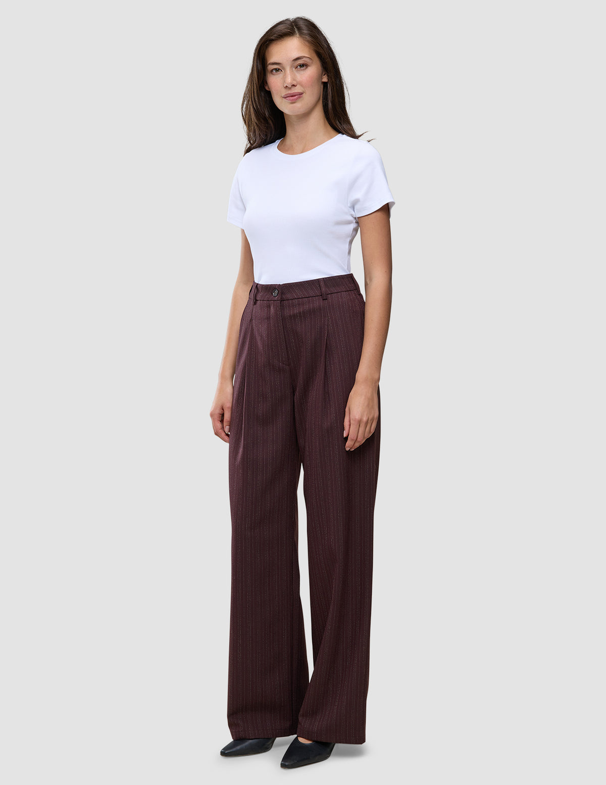 En kvinde iført en hvid T-shirt og et par Women Serene Pants Wide Berry Pinstripe.